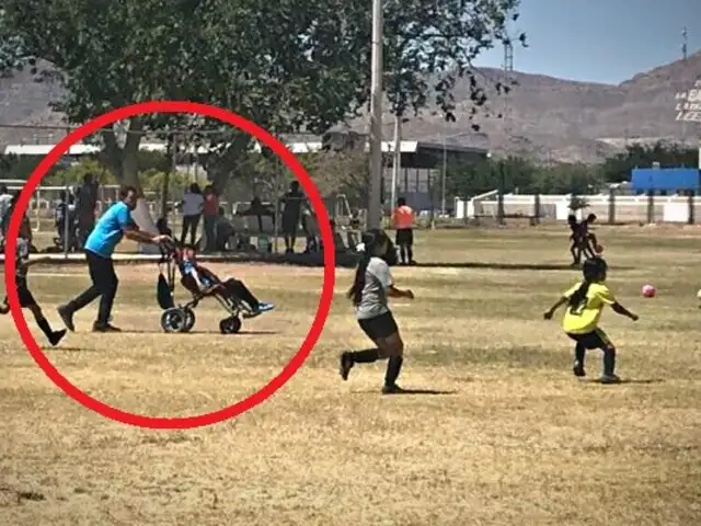 Niño en silla de ruedas juega fútbol impulsado por su padre