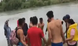 Inmigrantes rezan antes de cruzar el río Bravo, frontera de México y EE.UU
